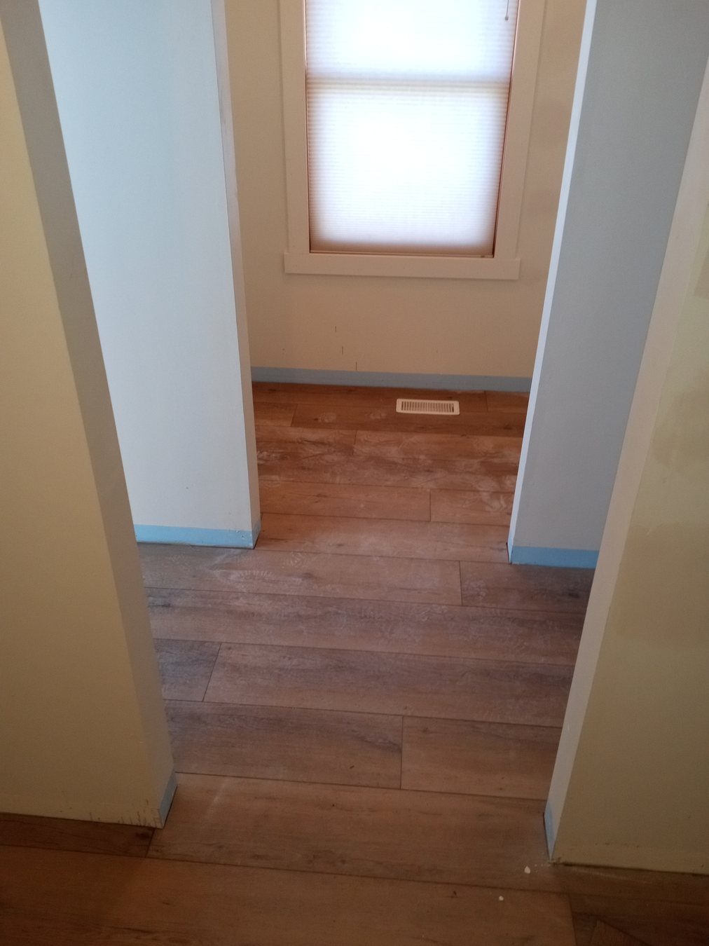 Fresh flooring and trim transition in a move-ready room.